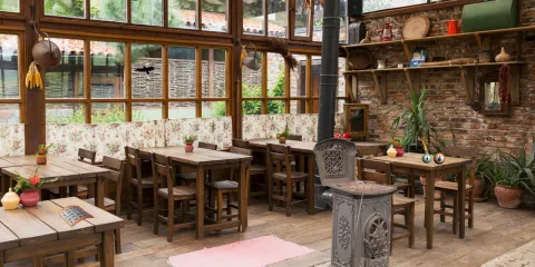 A photo of a cafe with a fireplace, several seats, and old fashioned furniture. 
