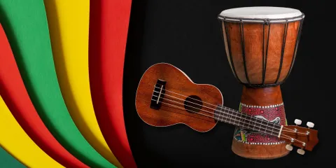 A rainbow of colors - green, yellow, and red - fill the left side of the image. On the right side, there is a black background with a drum and a guitar positioned on top. 